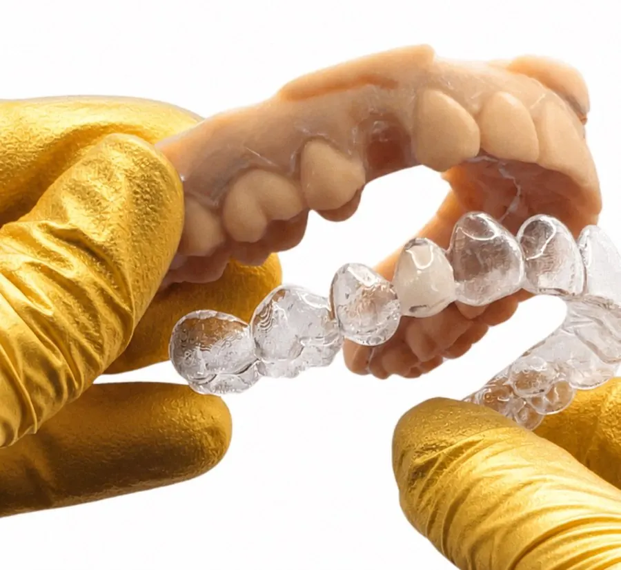 Clear essix retainer held in a gloved hand